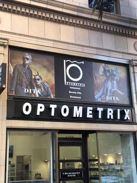 Adhesive vinyl window graphics installed above an optometry shop.